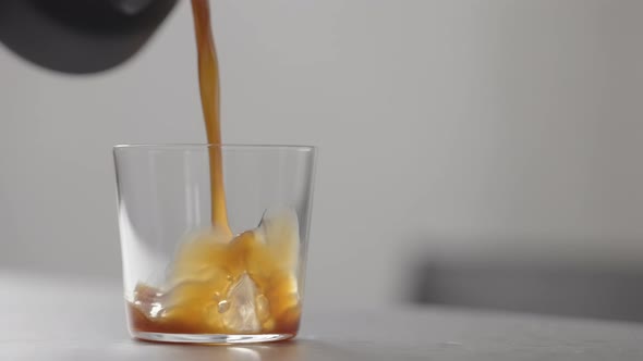 Slow Motion Pour Coffee in Tumbler Glass on Concrete Countertop with Copy Space alt