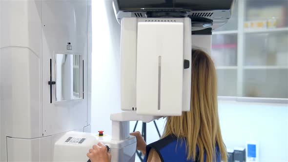Young Woman Patient Standing In Dental X-ray Machine For Dental Radiography
