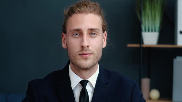 Young Serious Businessman is Looking Confident to the Camera with a Cute Smile alt
