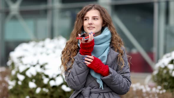 Portrait of Curly-Haired Woman With Phone Using the Voice Recognition AI Audio Message on the Phone