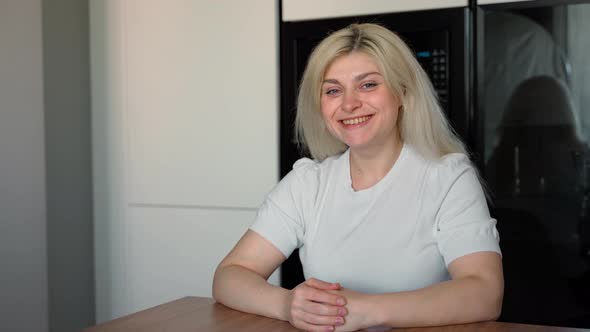 Beautiful smiling confident young caucasian ethnic woman pretty face looking at camera at home alt