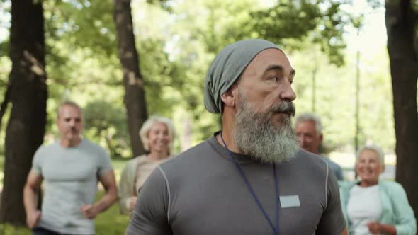Coach Having Outdoor Workout with Group of Seniors alt