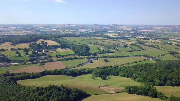 Rolling green hills of lush countryside landscape in Exeter, UK, AERIAL PAN alt