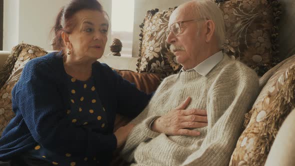 Caring understanding aged wife embracing comforting talking to upset grey haired elderly husband sha alt