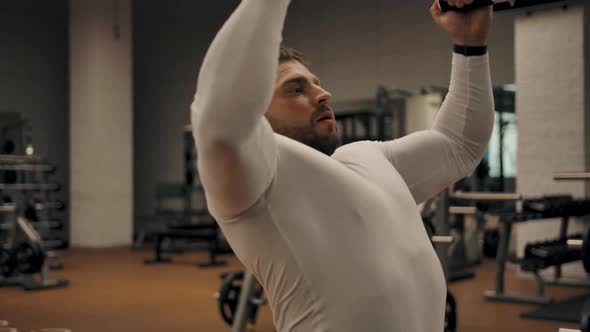 Male Doing Exercises for the Chest and Biceps on the Pull of the Upper Block alt