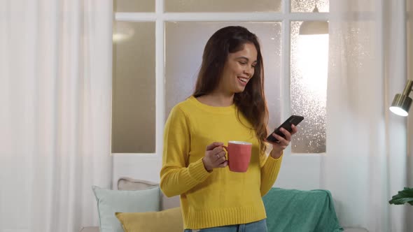 Caucasian woman using his phone and drinking coffee alt
