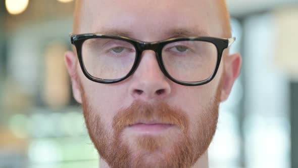 Close Up of Serious Face of Young Redhead Man  alt