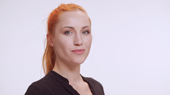 Confident Middleaged Caucasian Female in Dark Brown Shirt Touching Her Face and Smiling Then Leaving alt