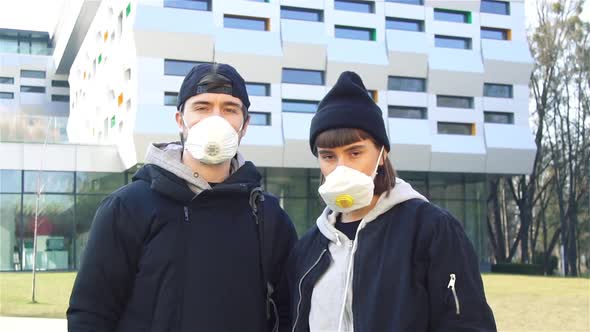 Alone Couple on Street in Respirators and Looking To Camera While Pandemic alt