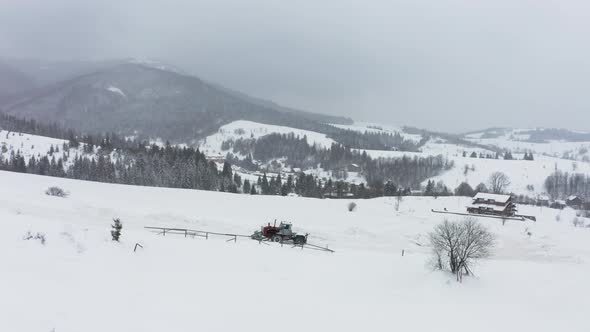 The Tractor Removes Snow From the Snowcovered Road so That the Cars Can Pass