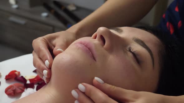 Female Massaging Womans's Face at Spa
