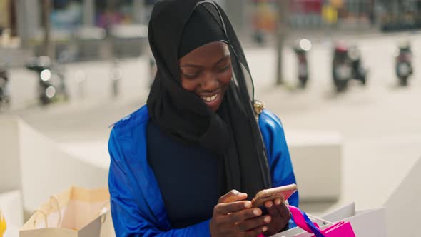 Muslim Woman Browsing Social Media After Shopping alt
