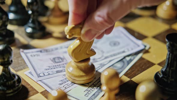 Money in US dollar bills on an old chessboard with retro chess pieces