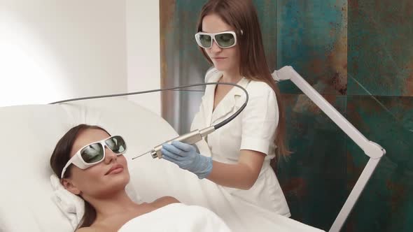 Cosmetologist Working on Woman Face with Beauty Apparat alt