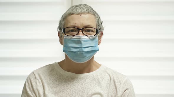 Portrait of an Elderly Woman in a Medical Mask After Chemotherapy