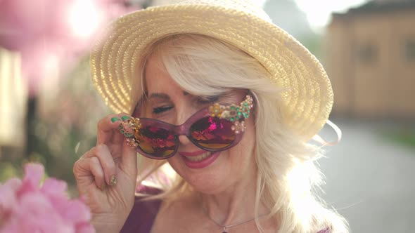 Headshot Smiling Adult Woman Winking Looking at Camera Putting on Sunglasses alt