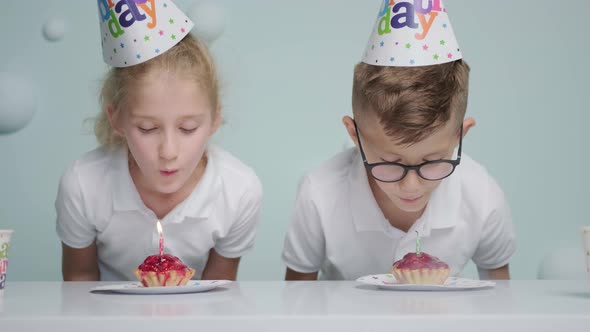 Birthday of Boy and Girl Twins with Cupcakes and Candle They Blow the Candles alt