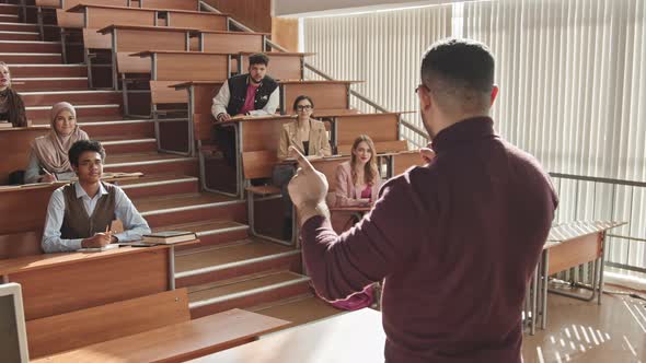Male University Professor Talking to Students during Seminar alt