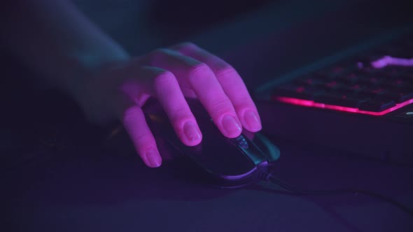 Playing Games in Neon Gaming Club - Woman Holding a Mouse alt