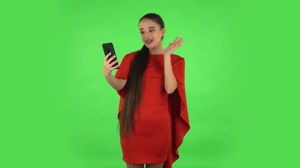 Pretty Young Woman Is Talking for Video Chat Using Mobile Phone and Rejoice. Green Screen alt