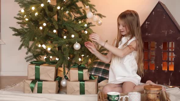 Smiling Beautiful Little Girl Holding New Year Gifts at Home