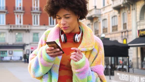 Young beautiful curly hair black woman outdoor in the city streaming live video blogging alt