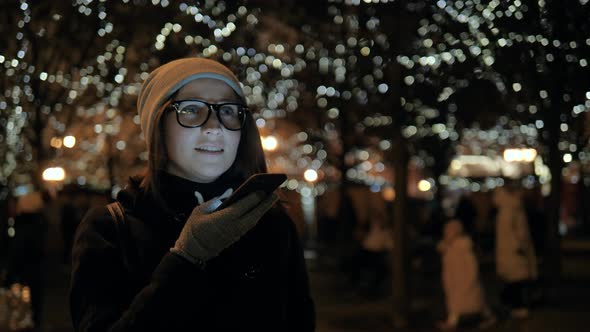 A Beautiful Young Woman Use Phone at Night Evening with Voice Recognition Ai Speech Audio Message alt