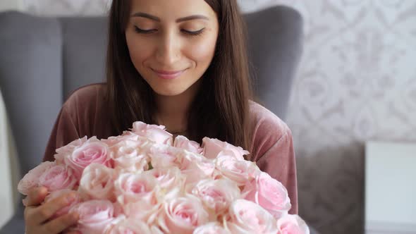 Happy Woman Look on Bouquet of Roses alt