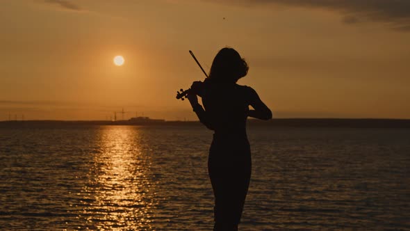Silhouette of Woman Violinist On Sunrise