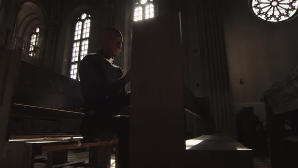 African-American Clergyman Praying in Christian Church alt