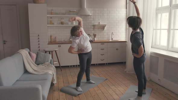 Mom and Daughter Finish the Home Fitness Exercise. alt