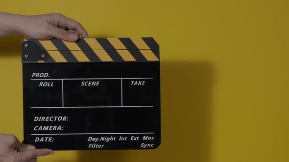 Clapper board. Close up hand and film making clapperboard isolated on background studio.