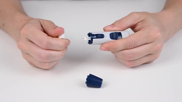 Caucasian Woman Doing a Glucose Test Using a Pen Lancet alt