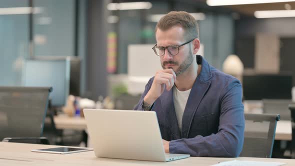 Middle Aged Businessman Talking on Video Call on Laptop in Office alt