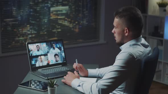 Back View of Young Businessman Having Online Meeting with Multinational Team of Young Leaders alt