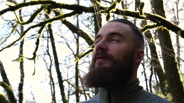 HEADSHOT of young bearded man amidst beautiful nature alt