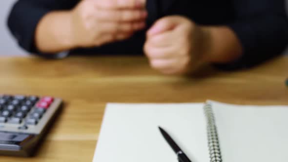 Ying hand holds Thai money and hands it to a business man.