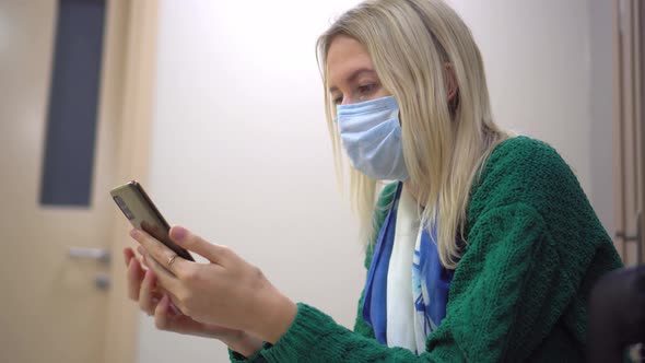 the blonde is sitting alone on a chair in the hospital with documents alt
