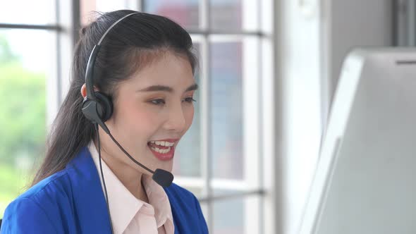 Businesswoman Wearing Headset Working Actively in Office alt