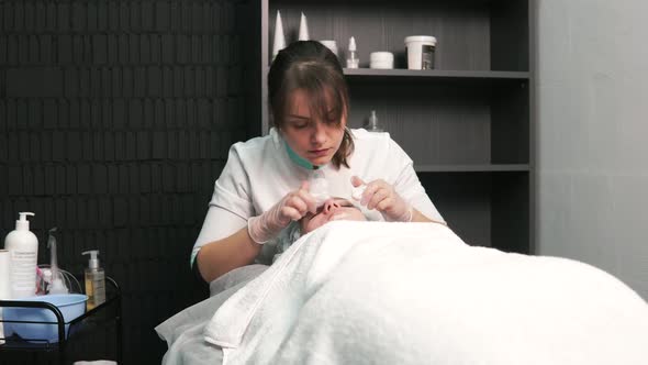 The Cosmetologist Cleanses the Face of Black Spots on the Nose with His Fingers