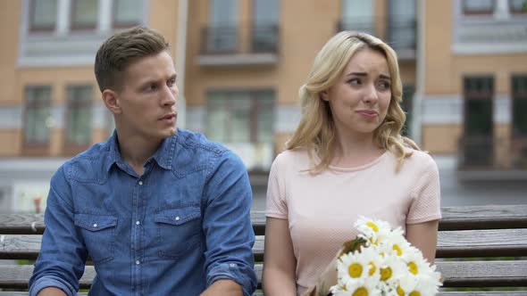 Male and female on bench gloomy, guy touching her shoulder, girl leaving, angry alt