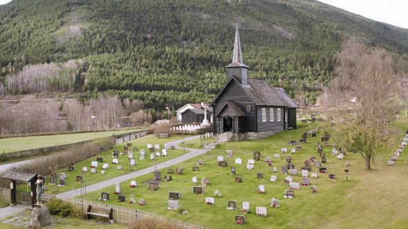 View On The Old Church Of Sel With Graves In Norway - aerial drone shot alt