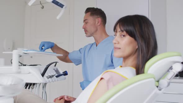 Portrait of smiling female patient with caucasian male dentist at modern dental clinic alt