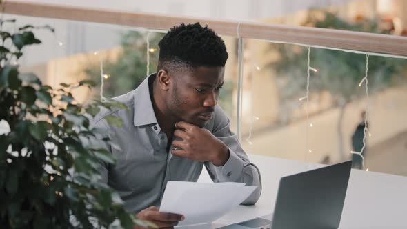 Young Male Manager Sitting at Workplace Checking Correctness Data on Laptop Serious Puzzled Pensive alt