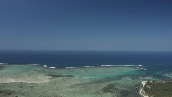 Aerial view of a person doing paragliding among the mountain, Mauritius. alt