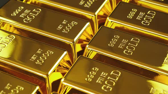 Gold bars arranged in a row in close up alt