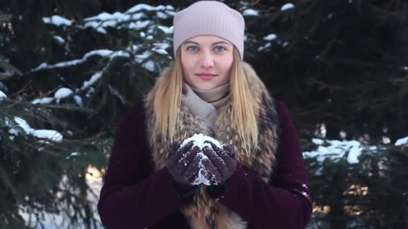 A Beautiful Girl Blows Snow From Her Hands in the Open Air in Winter Having a Good Build alt