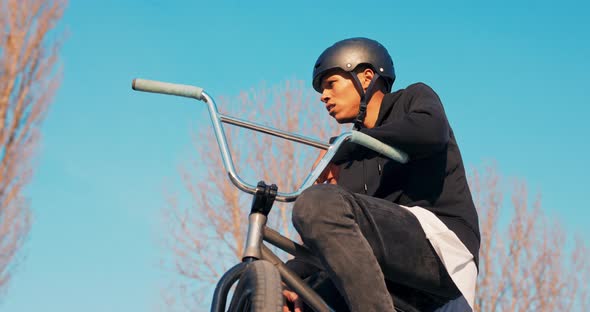 A Tired Darkskinned Man in Helmet is Resting Sitting on Low Bike He Has Lost alt