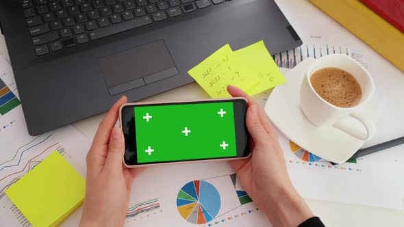 Business woman looking at green screen Mock-up Chroma Key of smartphone