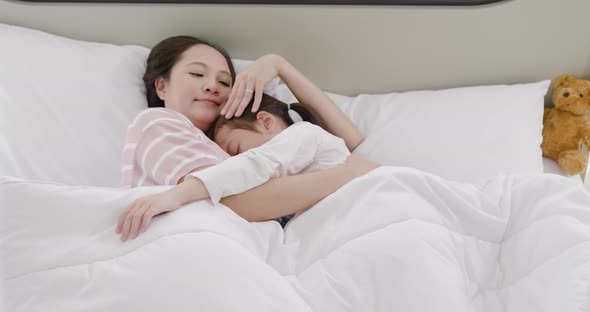 Mother and daughter are sleeping on the bed 3